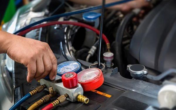 Skilled mechanic performing AC compressor replacement on a car or truck in the San Antonio TX auto repair shop.